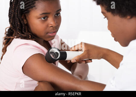 Dermatologe Kontrolle des Kindes auf der Haut des Patienten Stockfoto