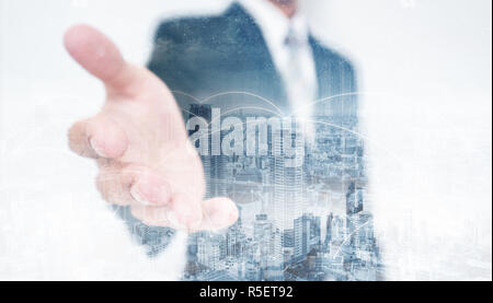 Double Exposure Geschäftsmann zur Verlängerung der Hand mit Stadtbild und Networking Technologie Stockfoto