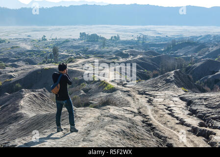 Mann an der Spitze der Schicht vulkanischer Asche wie Sand Boden des Mount Bromo Vulkan (Gunung Bromo) auf dem Bromo Tengger Semeru National Park, Ost Java, Indonesien Stockfoto