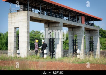 Geschäftsleute treffen mit Ingenieuren und Aufsichtsbehörden stehen die Baupläne auf der Baustelle zu lesen. Stockfoto