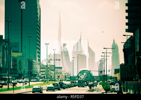 UAE, Dubai, Trade Centre Road, Burj Khalifa und Emirates Towers mit Al Karama Metro Station im Vordergrund Stockfoto