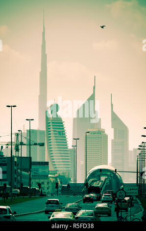 UAE, Dubai, Trade Centre Road, Burj Khalifa und Emirates Towers mit Al Karama Metro Station im Vordergrund Stockfoto