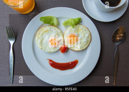 Glückliches Gesicht Braten Eier mit Kaffee zum Frühstück Stockfoto