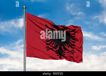 Flagge Albanien winken im Wind gegen Weiße bewölkt blauer Himmel. Stockfoto