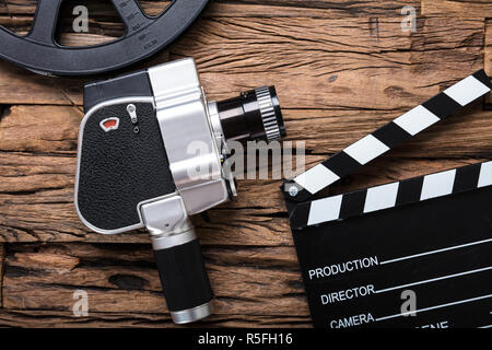 Film Kamera mit Filmrolle und Klappe auf Holz Stockfoto