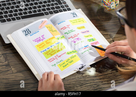 Unternehmer Schreiben Zeitplan im Tagebuch Stockfoto