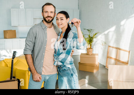 Lächelndes Paar an Kamera und Frau holding Keys von neues Haus suchen, Konzept bewegen Stockfoto