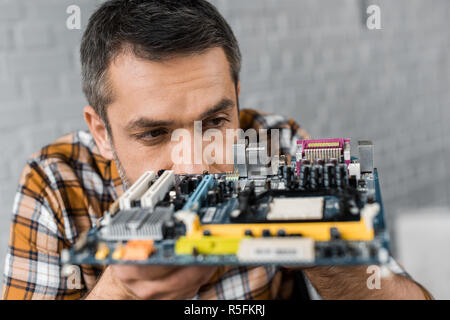 Close-up Portrait von Stattlichen computer Ingenieur mit Motherboard Stockfoto