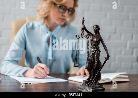 Nahaufnahme der Dame Gerechtigkeit Statue und weibliche Richterin hinter arbeiten Stockfoto