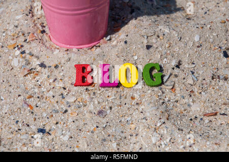 Buntes Holz- Buchstaben auf dem Sand Stockfoto