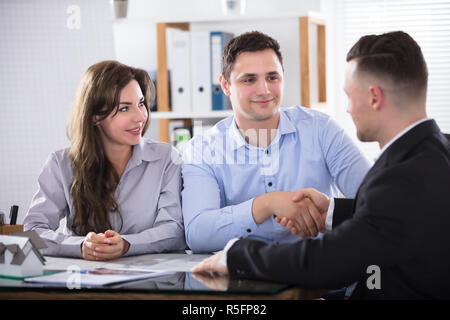 Paar Hände schütteln mit Real Estate Advisor Stockfoto