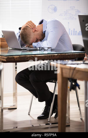 Geschäftsmann Schlafen über den Schreibtisch Stockfoto