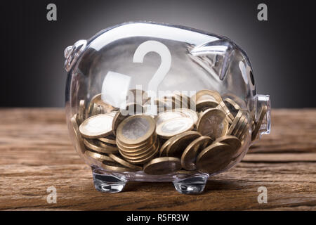 Fragezeichen und Münzen in transparenten Piggy Bank Stockfoto