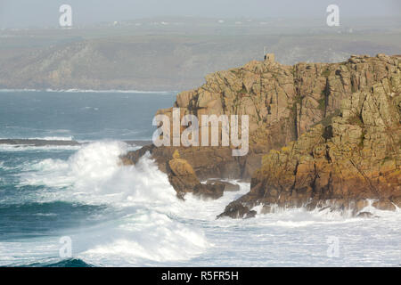 Wellen über pedn Men Du in der Nähe von Sennen Cove in Cornwall. Stockfoto