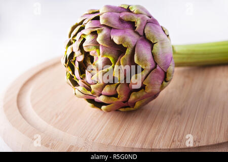 Frische Artischocke auf einem hölzernen Platte Stockfoto