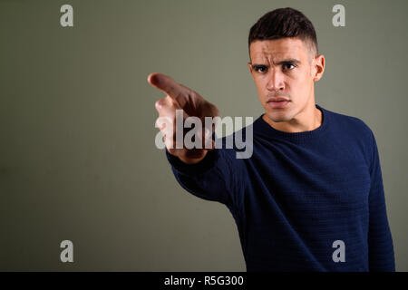 Jungen gutaussehenden Mann mit Pullover gegen farbigen Hintergrund Stockfoto