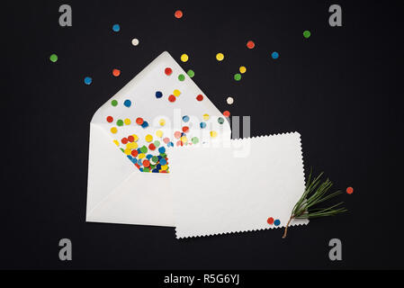Umschlag mit Weihnachten Grußkarte und festliche Konfetti auf schwarzem Hintergrund. Leere weiss Hinweis Stockfoto