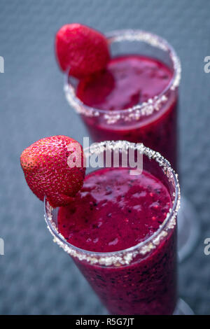 Closeup of two glasses filled with fresh strawberry juice and sugar decoration, top view. Stockfoto