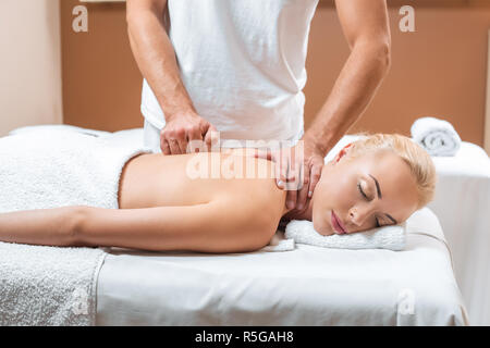 Männlichen masseur Massage zu tun, schöne Frau mit geschlossenen Augen in Spa. Stockfoto