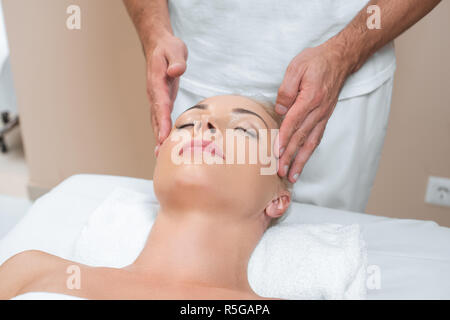 Männlichen Masseur, Gesichtsmassage, Frau in Spa Salon Stockfoto