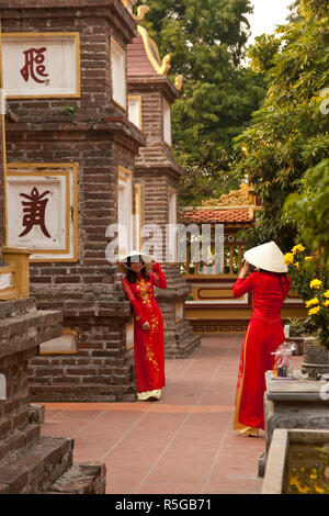 Mädchen, die Ao Dai Kleid, Tran Quoc Pagode, West Lake (Ho Tay), Hanoi, Vietnam (MR) Stockfoto