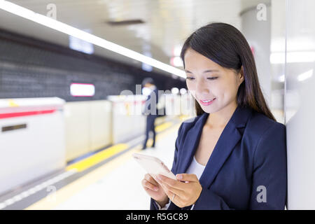 Asiatische Geschäftsfrau Arbeiten am Handy in Bahnhof Stockfoto