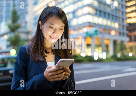 Business woman Nutzung Handy in Tokyo City Stockfoto