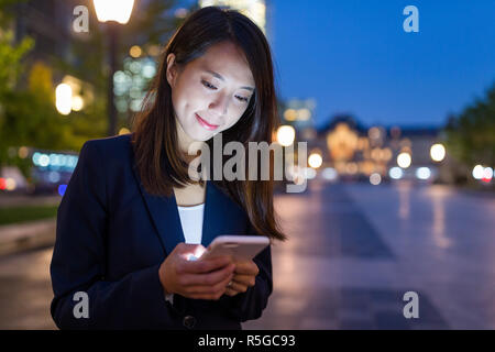 Business woman Nutzung von Mobiltelefonen in Tokyo City Stockfoto