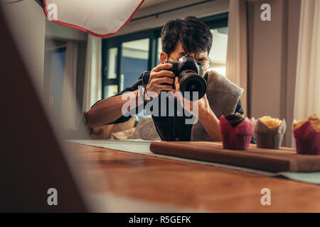 Essen Fotografen mit digitalen Kamera ein Foto von Dessert. Professionelle Fotografen, die während der Aufnahmen in seinem Studio. Stockfoto