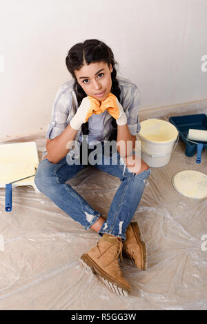 Hohe Betrachtungswinkel und der schöne junge Frau sitzt auf dem Boden bei der Renovierung des Home Stockfoto