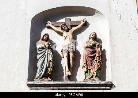 Trier, Deutschland. Christus am Kreuz mit der Jungfrau Maria und der hl. Johannes in St. Gangolf Kirche Stockfoto