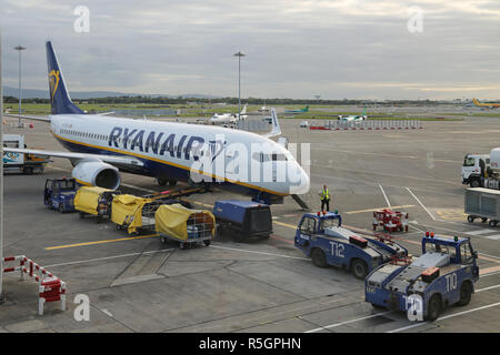 Eine Ryanair Boeing 737 Parks auf dem Vorfeld des Internationalen Flughafen Dublin, Irland, Klemme 2. Zeigt Gepäck laden und Service Fahrzeuge. Stockfoto