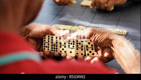 Schwarz pensionierte ältere Mann spielt Domino Spiel mit Freunden Stockfoto