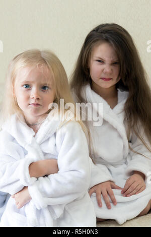 Die zwischen den beiden Schwestern disgruntled böse Gesichter Emotionen der Kinder streiten. Stockfoto