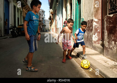 Eine Gruppe von jungen Jungen Fußball spielen auf den Straßen von Havanna, Kuba Stockfoto