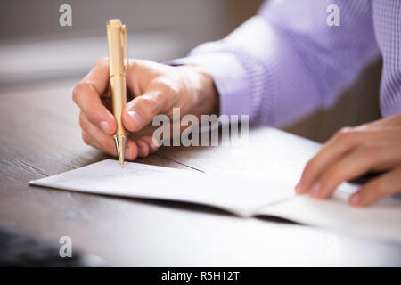 Der Unternehmer Hand Unterzeichnung prüfen Stockfoto