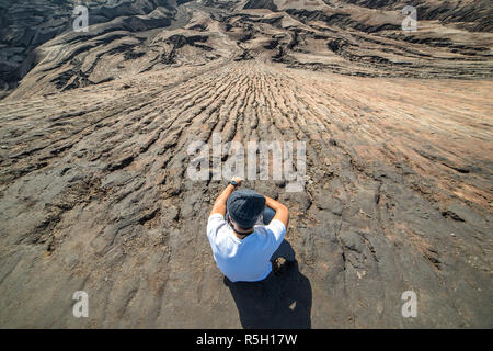 Mann an der Spitze der Schicht vulkanischer Asche wie Sand Boden des Mount Bromo Vulkan (Gunung Bromo) auf dem Bromo Tengger Semeru National Park, Ost Java, Indonesien Stockfoto