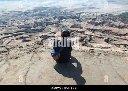 Mann an der Spitze der Schicht vulkanischer Asche wie Sand Boden des Mount Bromo Vulkan (Gunung Bromo) auf dem Bromo Tengger Semeru National Park, Ost Java, Indonesien Stockfoto