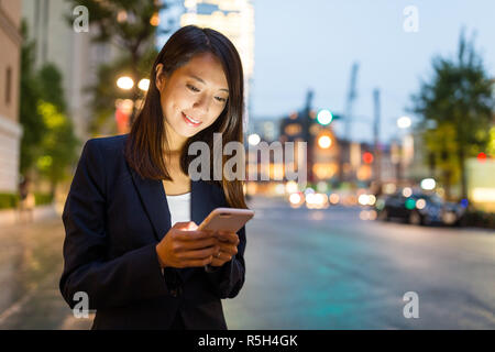 Geschäftsfrau auf Handy in Tokyo City Stockfoto