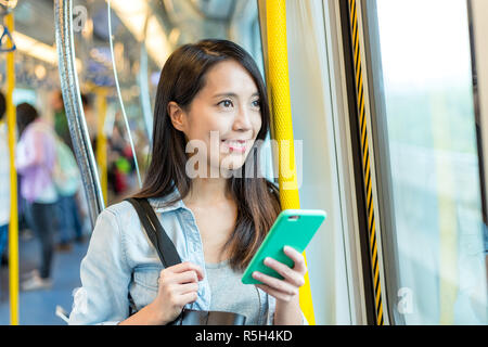 Frau mit Handy im Zug Stockfoto