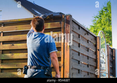 Malerei der Schutzlack auf einem hölzernen Zaun Stockfoto