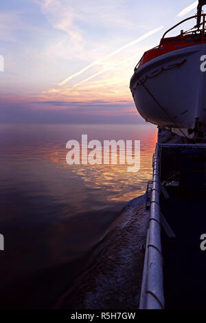 Rettungsboot auf einem Schiff im Sonnenuntergang. rettungsboot auf einem Pass Stockfoto