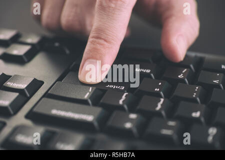 Person die Eingabe über die Tastatur und Drücken der ENTER-Taste. Close Up. Stockfoto