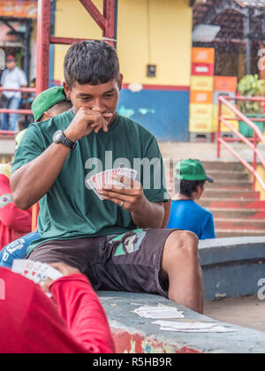 Tabatinga, Brasilien - 15. September 2018: Die brasilianischen Mann spielt die Karten während der einen regnerischen Tag im Hafen des Amazonas. Tres Fronteras. Lateinamerika Stockfoto