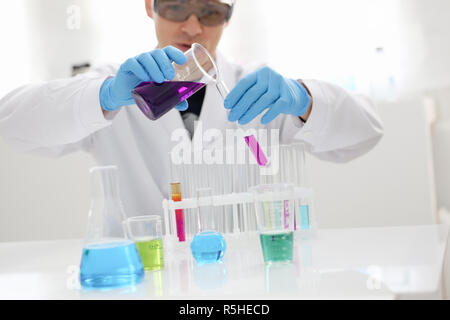 Eine männliche Chemiker hält Reagenzglas von Glas in Stockfoto