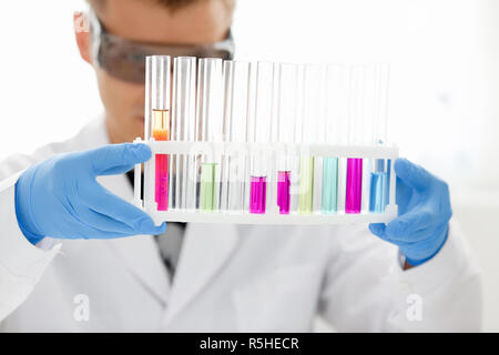 Eine männliche Chemiker hält Reagenzglas von Glas in Stockfoto