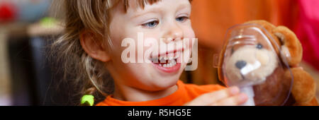 Glückliches Kind macht Inhalation zu Hause für Stockfoto