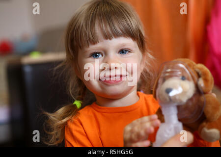 Glückliches Kind macht Inhalation zu Hause für Stockfoto