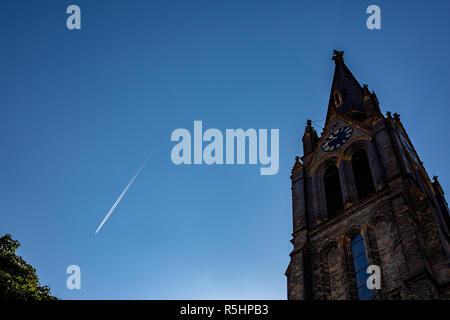 Blauer Himmel mit dem Flugzeug Trail und die Vorderseite der Kathedrale im gotischen Baustil mit Uhrturm in der Altstadt von Prag, Tschechische Republik Stockfoto