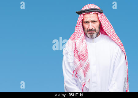 Senior arabischen Mann mit kufiya über isolierte Hintergrund gedrückt und für Not, Sorge und schrie wütend und ängstlich. Traurigen Gesichtsausdruck. Stockfoto